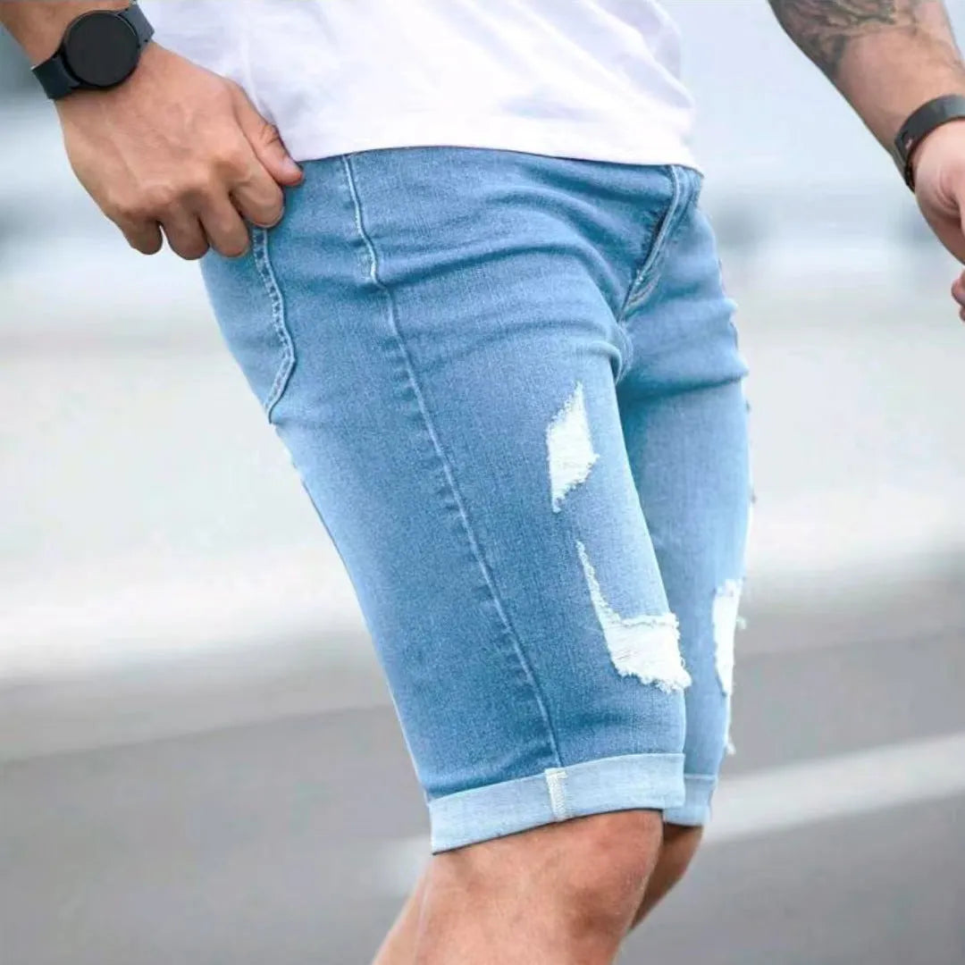 Sky blue men's denim shorts with a multi-hole distressed design on the front, showing a low waist and straight leg cut.