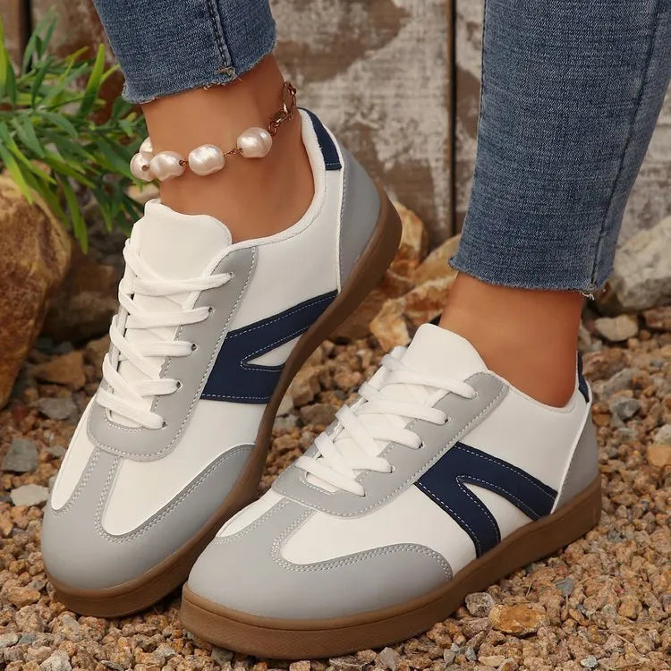 Blue women's low-top flat training shoes with lace-up front and rubber sole.