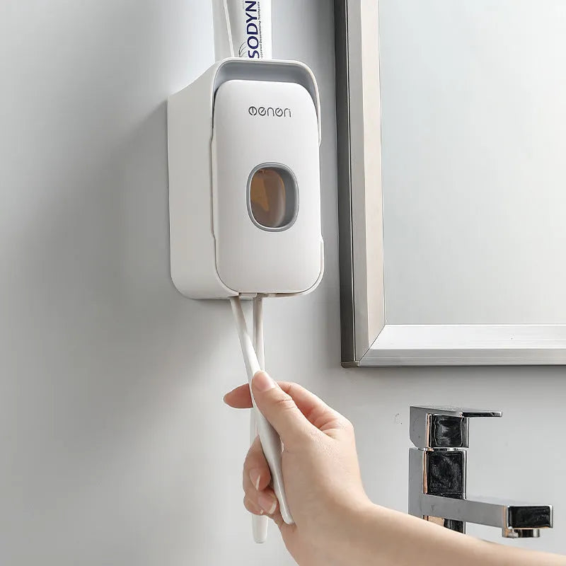 Blue automatic toothpaste dispenser mounted on bathroom wall with one-touch dispensing mechanism