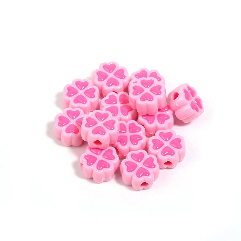 A selection of 15mm frosted acrylic beads in various colours, each showing a four-leaf clover love pattern.