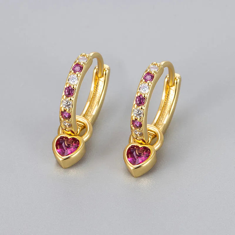A pair of women's dangle earrings with a heart-shaped frame holding a coloured zircon stone.