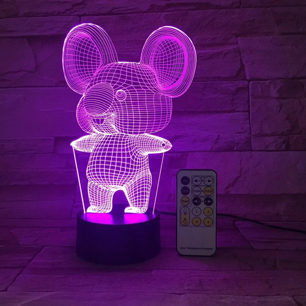 Black koala-shaped LED night light with remote control on a table, showing multi-colour illumination.