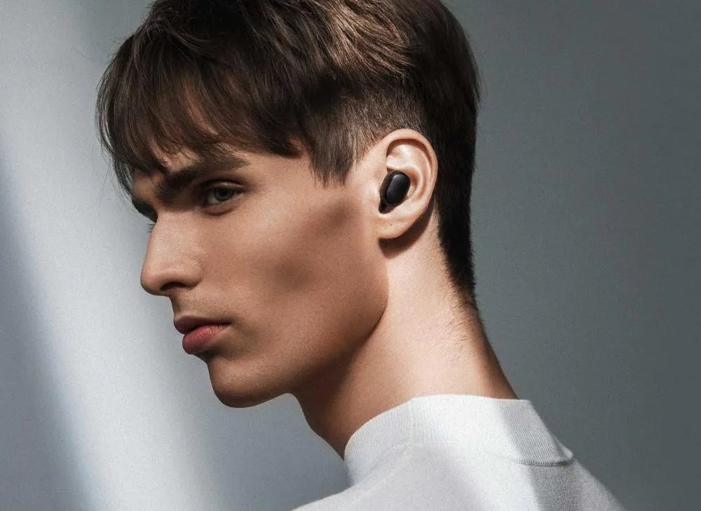 Black Redmi AirDots true wireless earbuds and charging case on a white background.