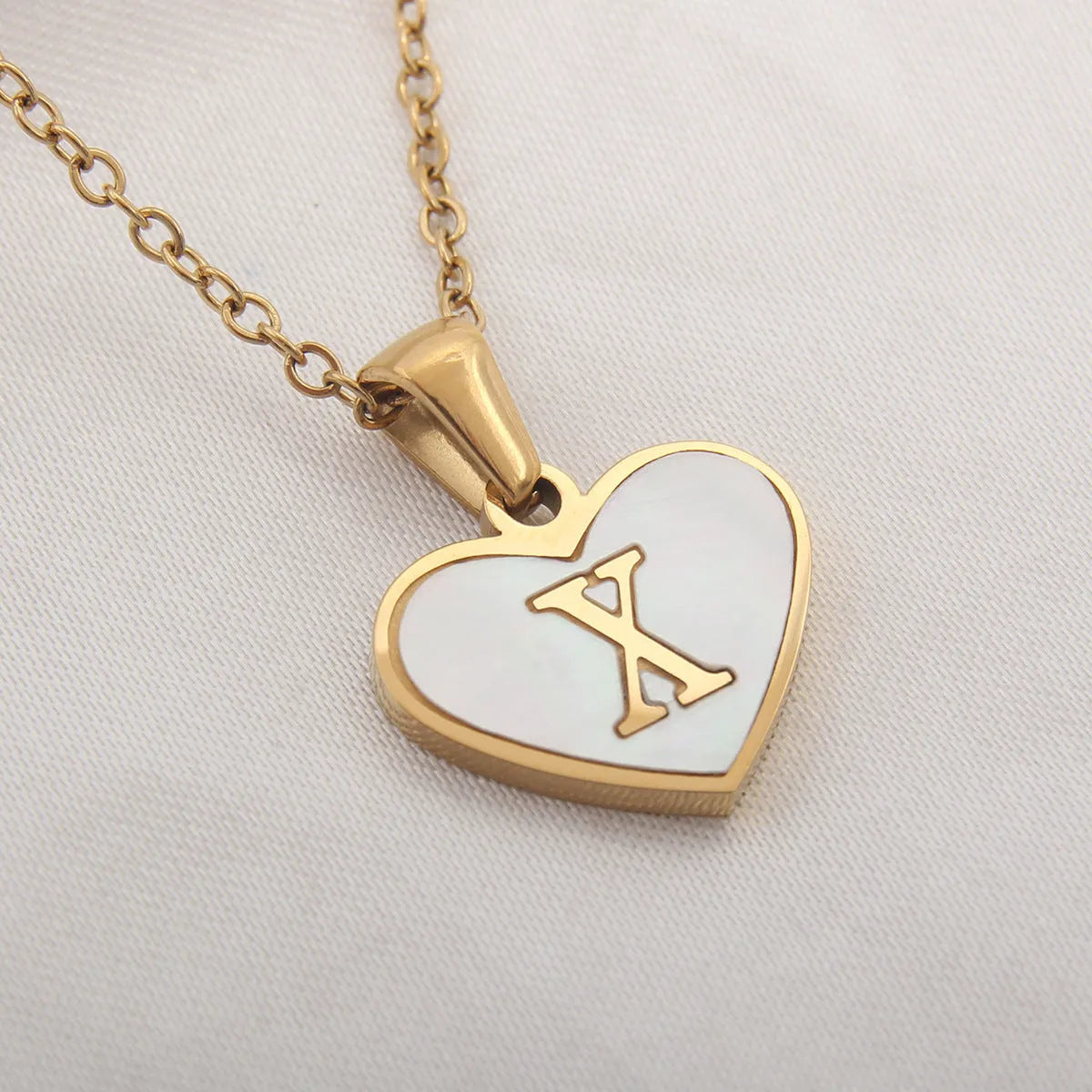 Gold plated heart necklace with white shell detail on an adjustable chain