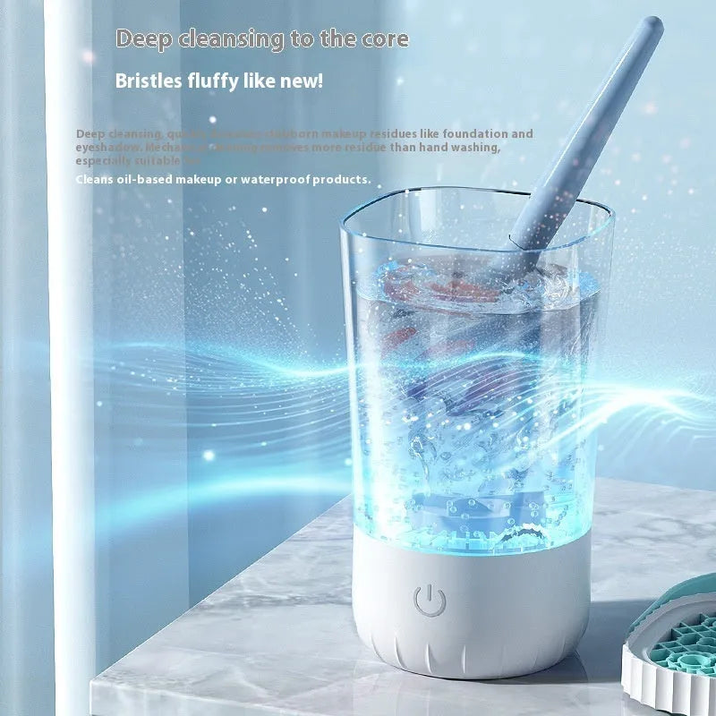 White rechargeable electric makeup brush cleaner with USB cable on a table.
