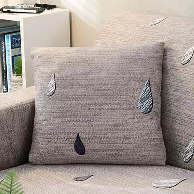 Geometric print stretch sofa slipcover fitted on a grey three-seater sofa.