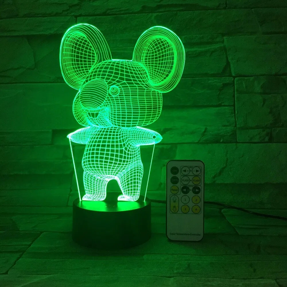 Black koala-shaped LED night light with remote control on a table, showing multi-colour illumination.