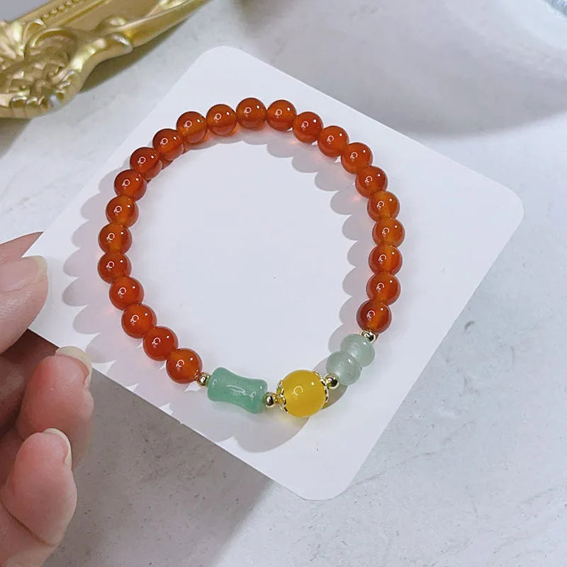 Handmade red agate women's bracelet with dragon design on a wrist.