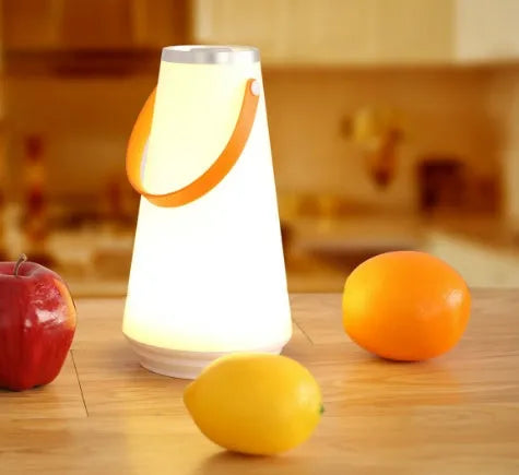 White rechargeable LED lantern night light with USB cable on a table