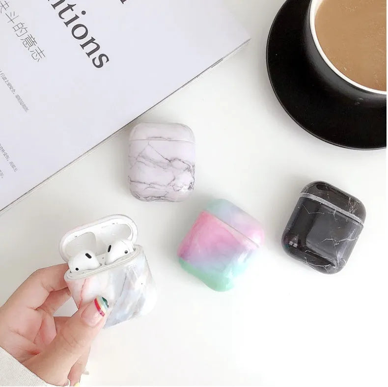 Hard white marble-pattern PC protective case fitted on an AirPods wireless earbud charging box.