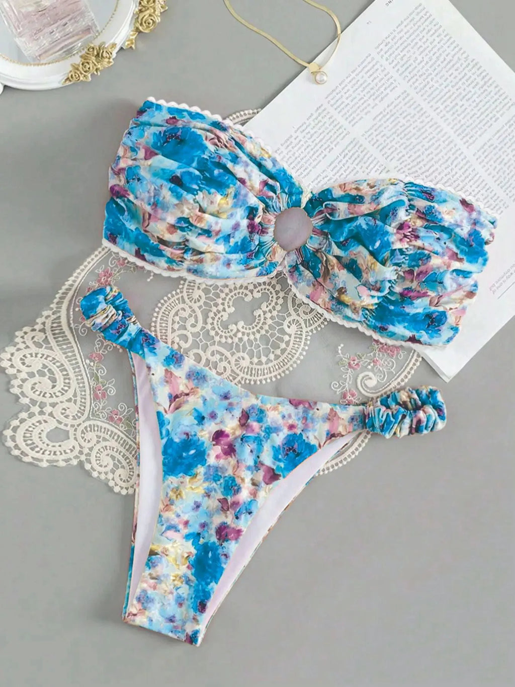 Women's floral print bikini set with lace trim on a tube top and briefs in blue.