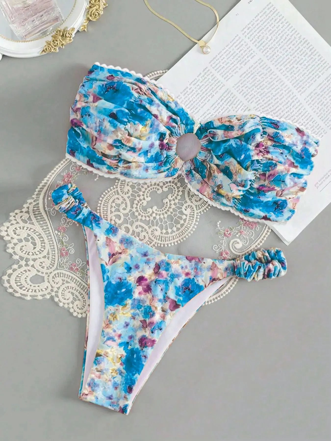 Women's floral print bikini set with lace trim on a tube top and briefs in blue.