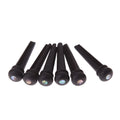 Six ebony guitar bridge pins with matt black finish on dark surface