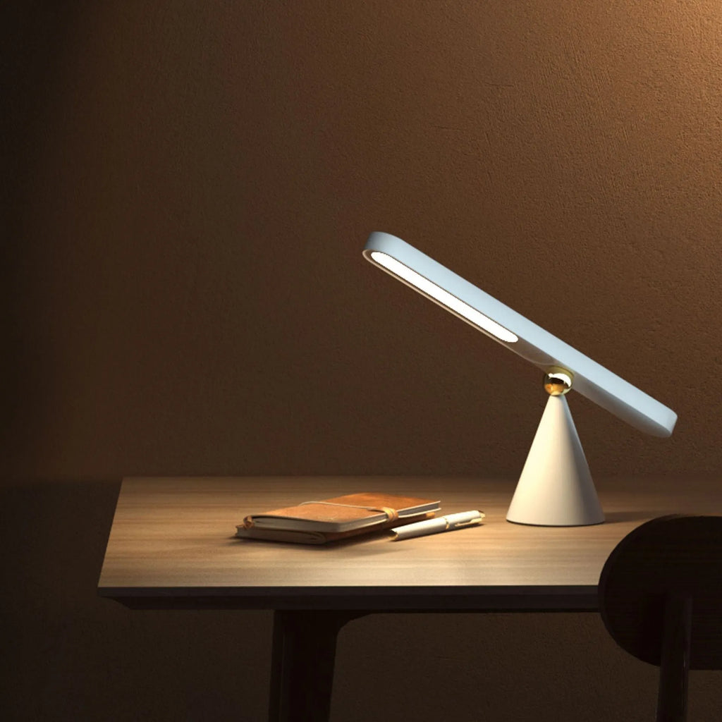 White geometric desk lamp with magnetic suction base and touch control on wooden desk