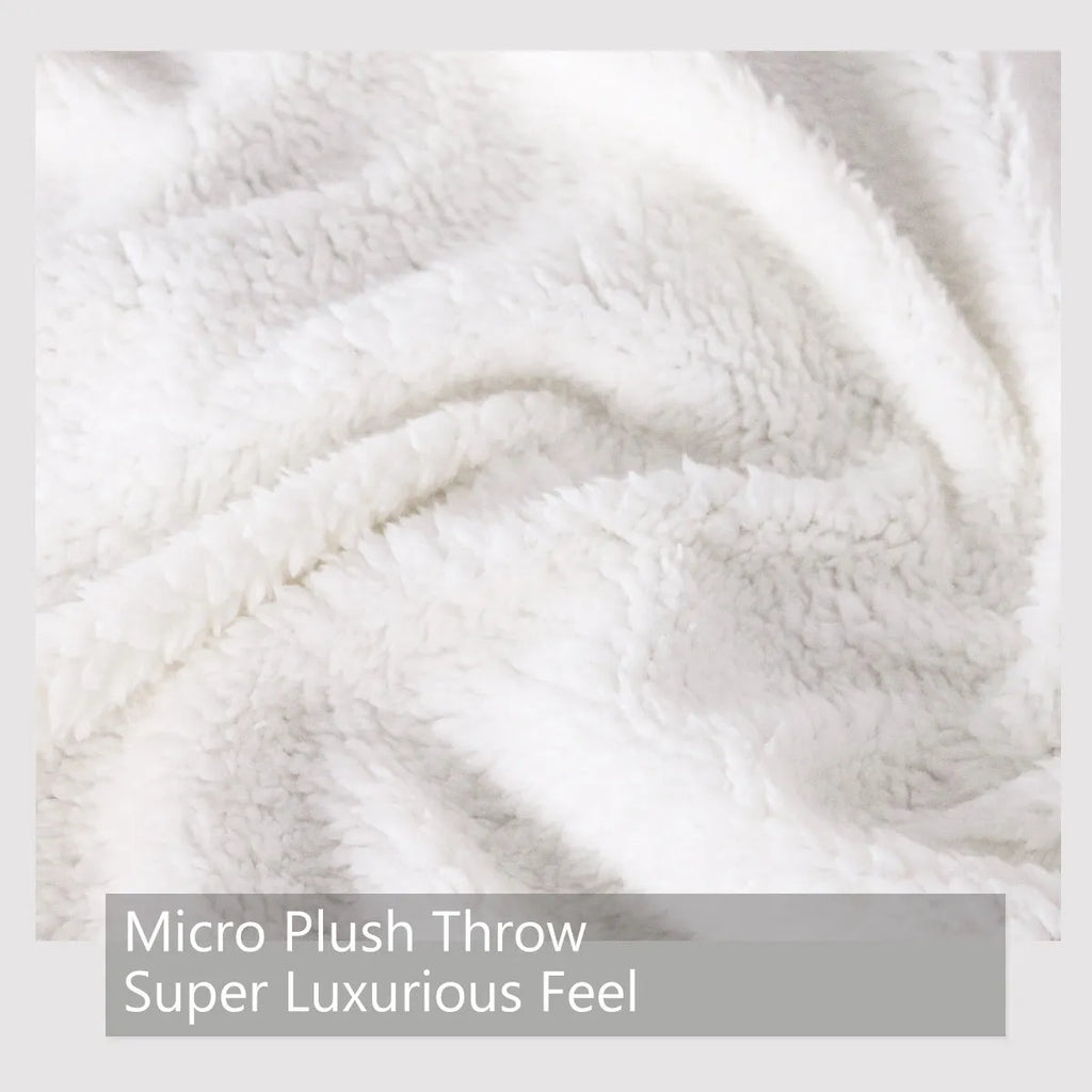 Black Sherpa fleece blanket with high weight, soft texture, and hemmed edges on a sofa