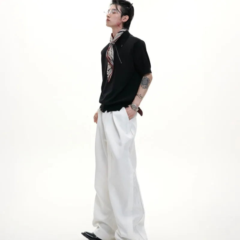 Man modelling a slim-fit black knitted polo shirt with an oblique zip and short sleeves.