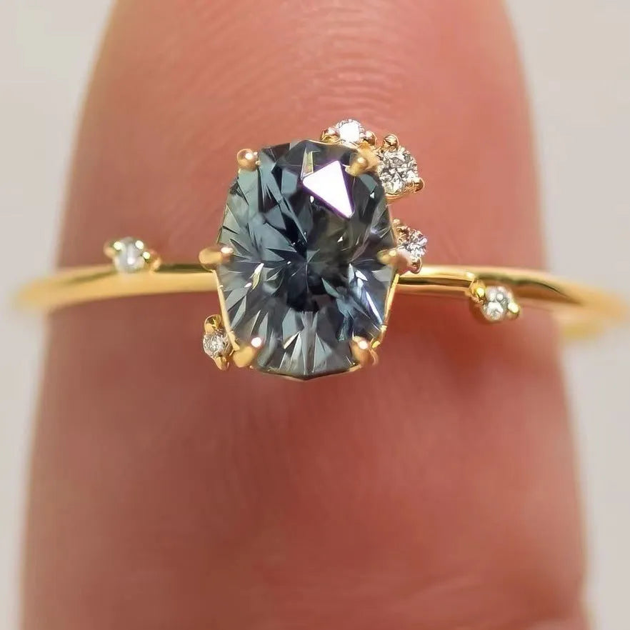 Gold-plated floral fashion ring with a central green zircon stone on a hand.