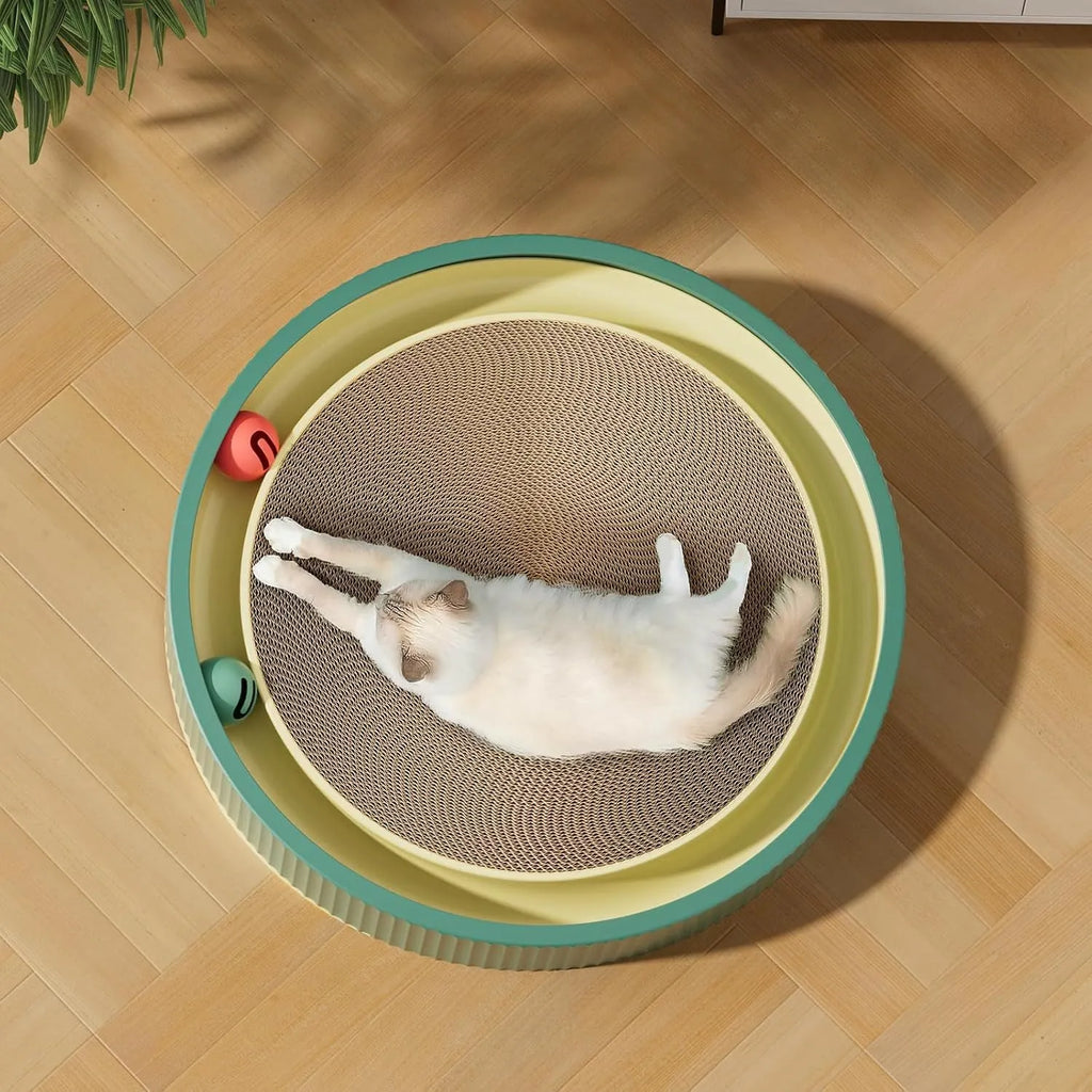 Large circular green cardboard cat scratching board with a central track containing two yellow balls and a spring-mounted plush ball.