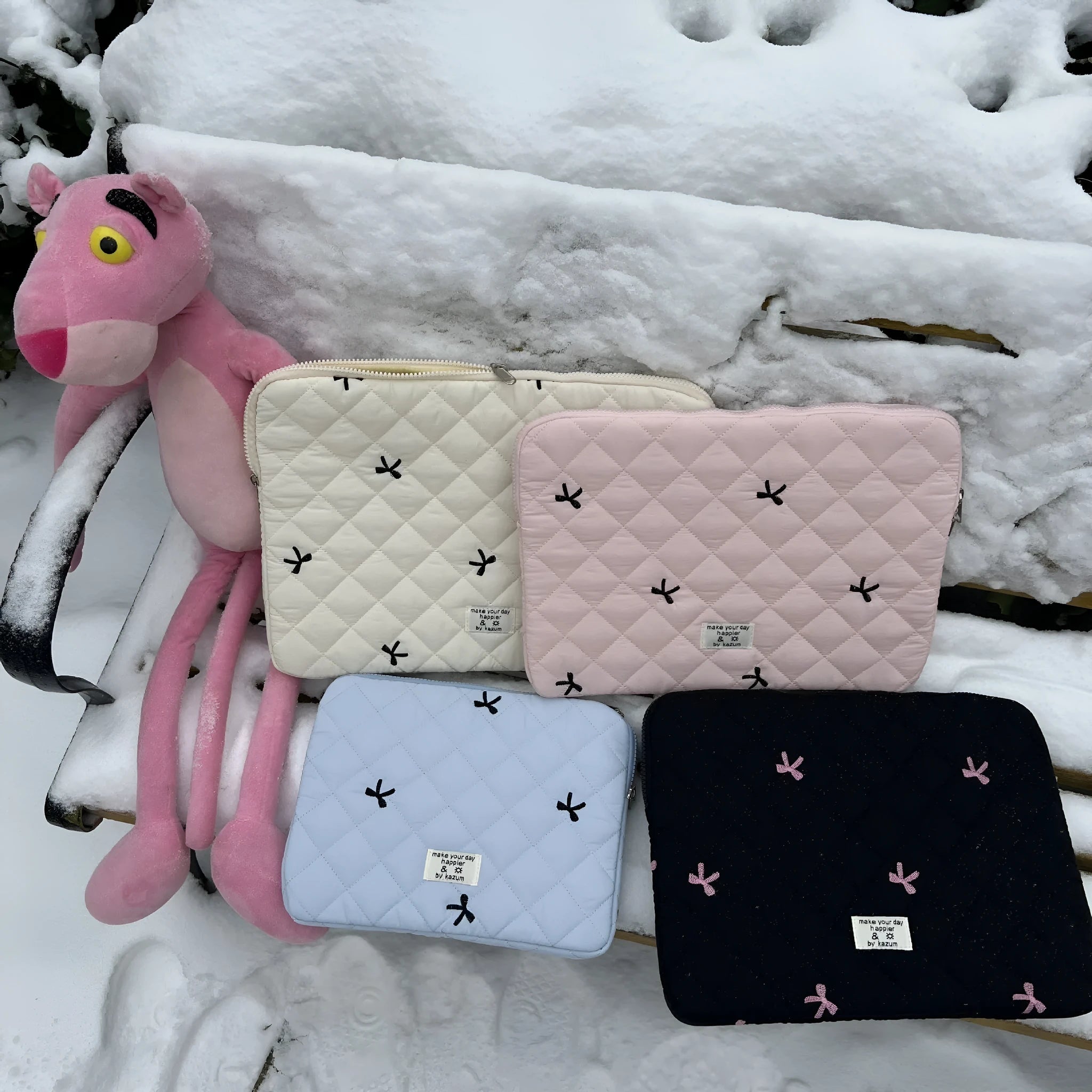 Nylon laptop storage bag with embroidered rhombus and bow design in light blue.