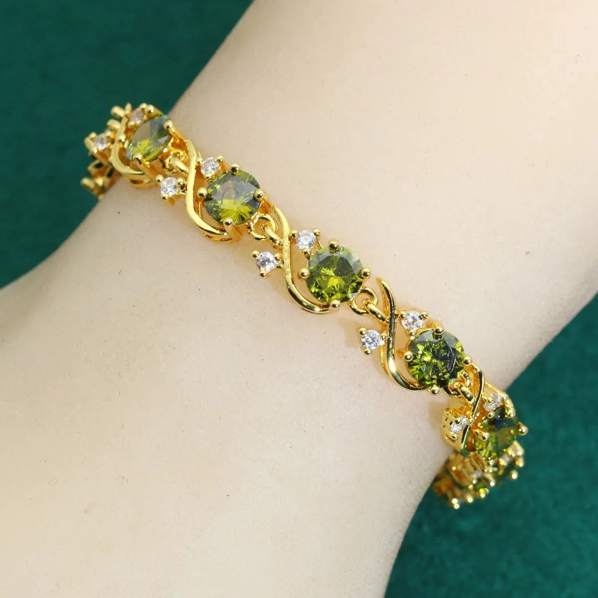 Female model wearing a golden green AAA zircon inlaid copper bracelet with a retro leaf shape design.