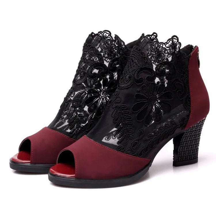 Black lace gladiator sandals with a square high heel and zip closure on a woman's foot.