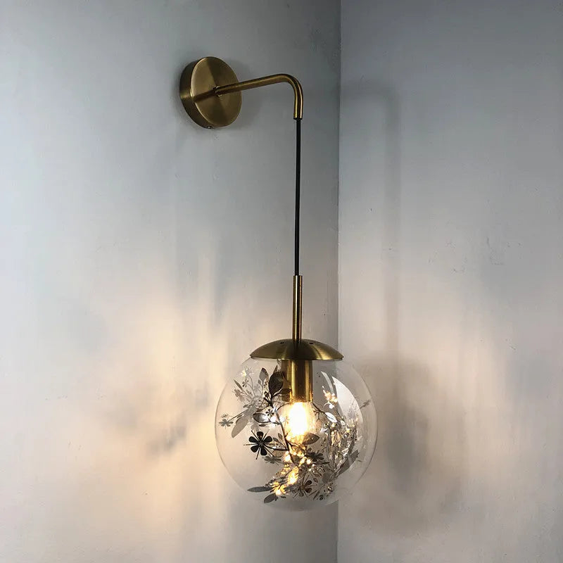 Modern glass wall lamp in golden flower finish mounted beside bed