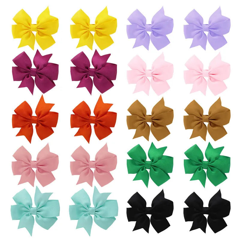 Assortment of colourful 3-inch grosgrain ribbon pinwheel hair bows with alligator clips for toddlers.