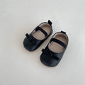 Baby shoes in white with bow detail, non-slip rubber sole, and elastic band fastening