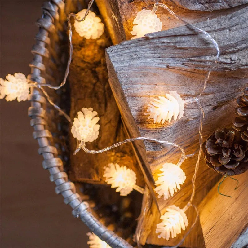 Warm white battery-powered LED pine cone lights on a string for festive decoration.