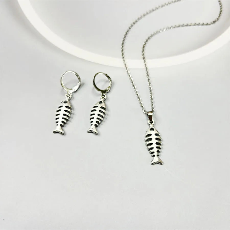 Fishbone pendant earrings and matching necklace set with adjustable chain on grey background