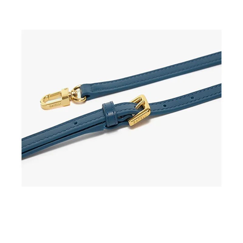 A wing-shaped cow leather tote bag with a buckle latch closure, shown in blue with a single cross-body strap.