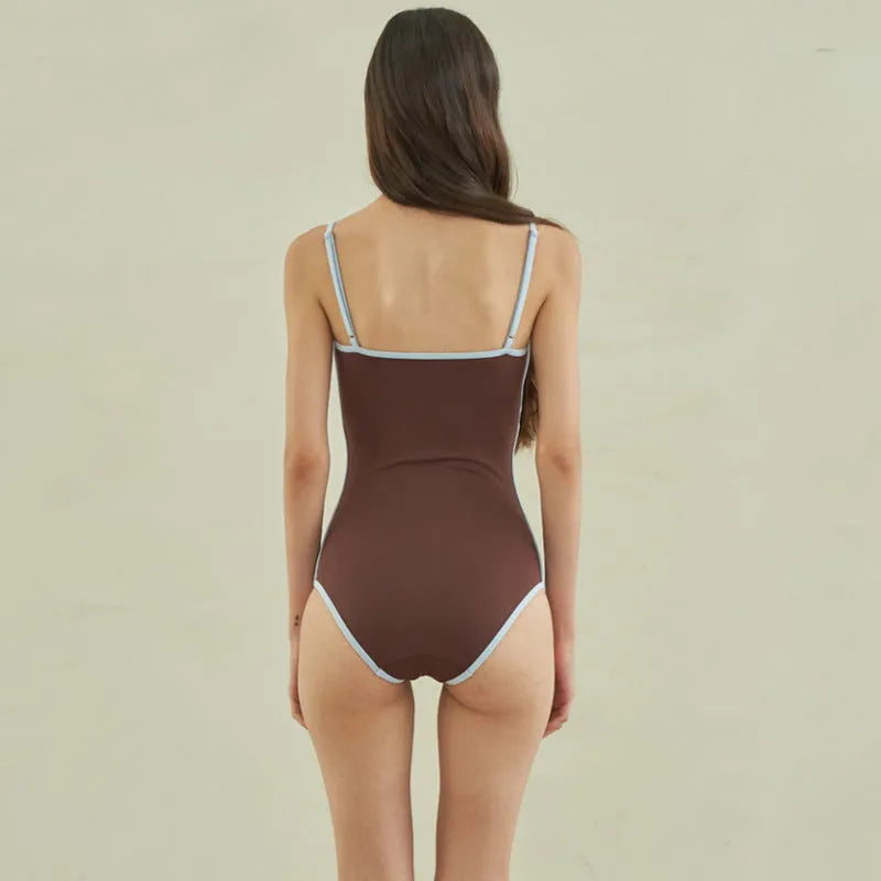 Brown triangle top one-piece swimsuit for women on a hanger.