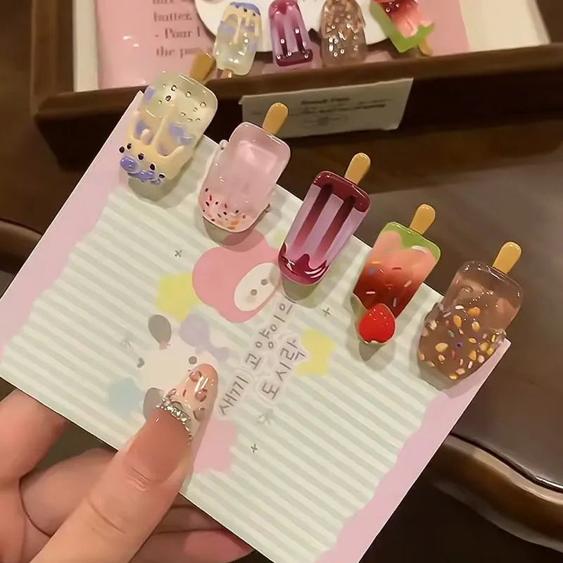 Close-up of a resin hair clip with a colourful cartoon ice cream design, shown in beige.