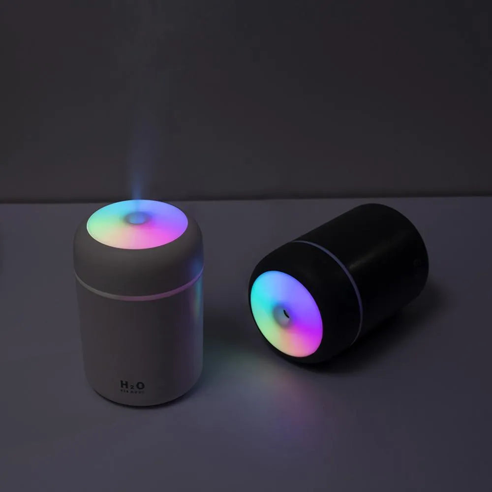 USB mini humidifier with colourful lights in pink, white, or navy blue colours on a desk