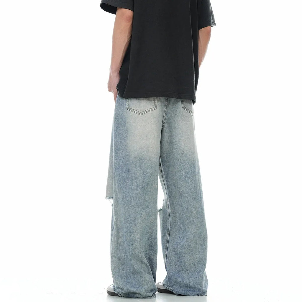 Blue men's straight-leg ripped jeans on a neutral background, showing the cotton blend fabric and zipper fly detail.