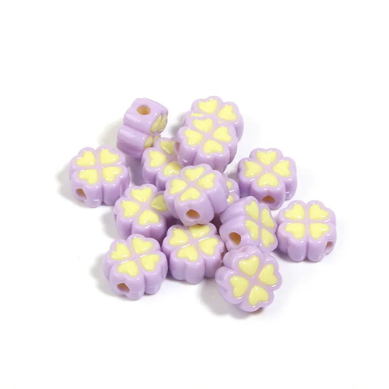A selection of 15mm frosted acrylic beads in various colours, each showing a four-leaf clover love pattern.