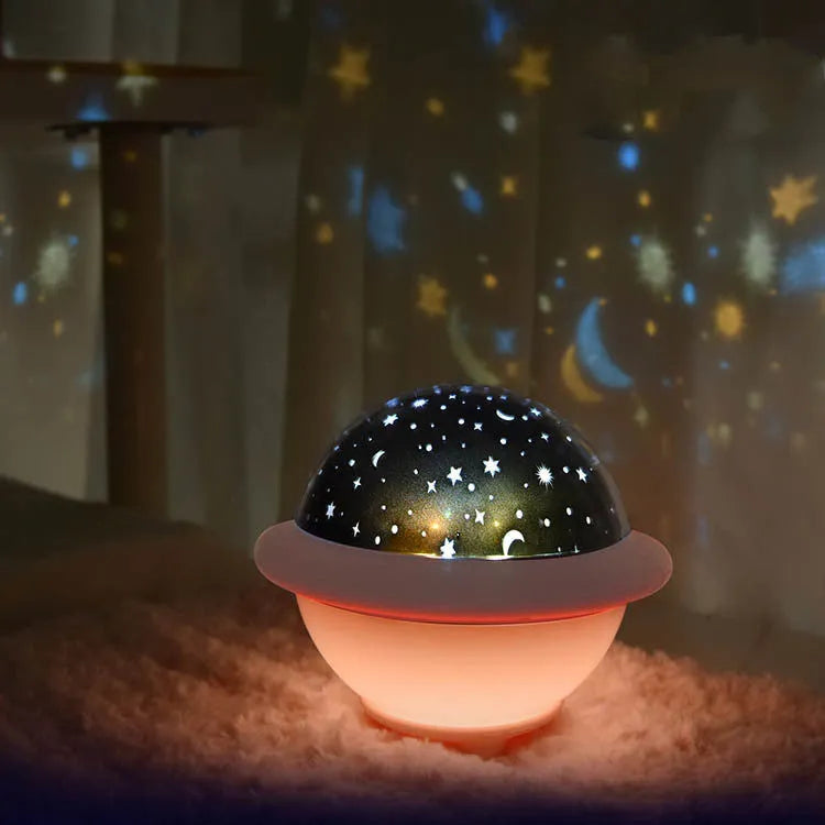 Green UFO-shaped plastic night light projecting starry sky pattern on a wall