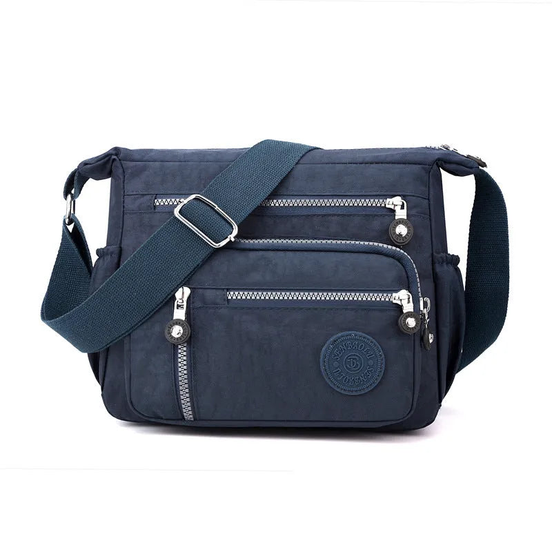 Lightweight nylon shoulder messenger bag in square vertical shape with single strap.