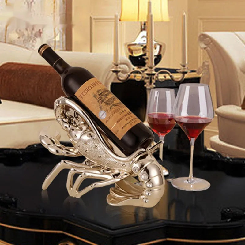 Rose gold and silver lobster-shaped plastic and resin wine rack ornament on a tabletop.