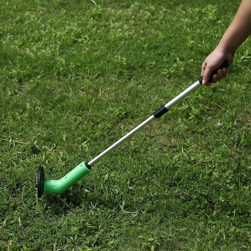 Cordless handheld lawn trimmer with extension pole and protective shield on green grass