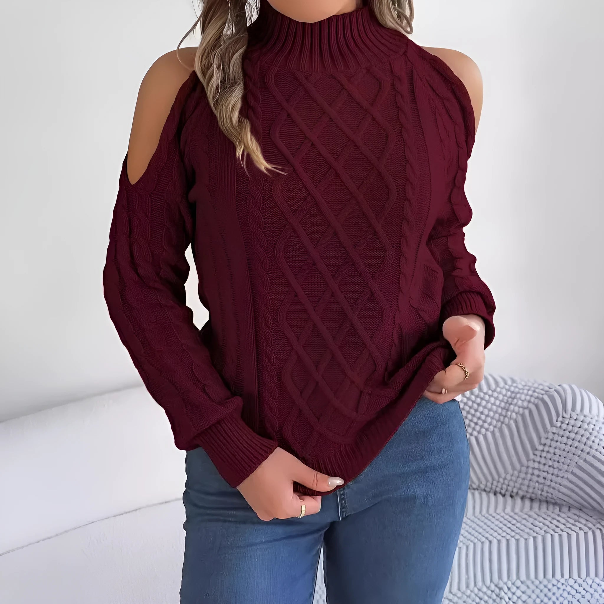 Woman wearing a grey twisted strapless sweater with half-high collar and lantern sleeves.