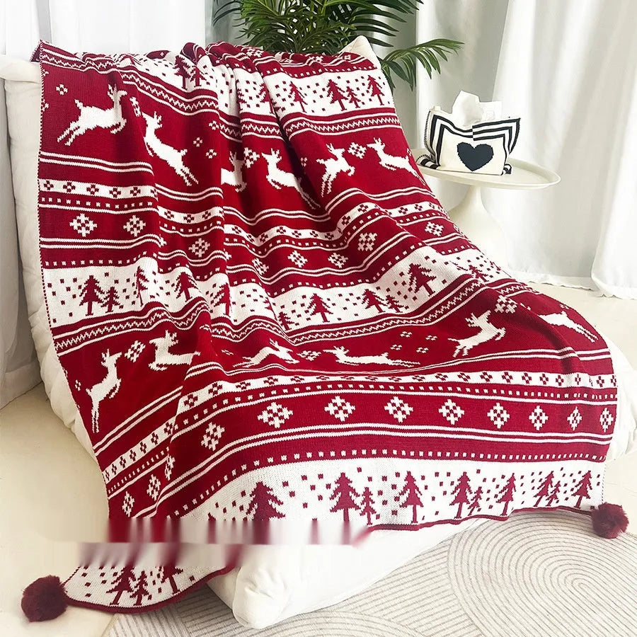 Personalised acrylic Christmas blanket with snowflake or reindeer pattern on a sofa.