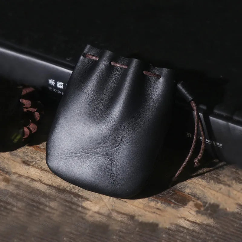 Vintage style cowhide leather drawstring bundle wallet in black, showing sewing thread detail and drawstring closure.