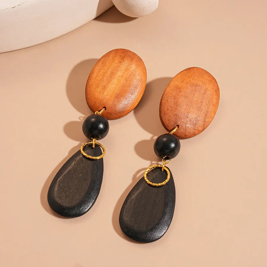 Brown-black wooden retro earrings with elliptical design and silver needle details