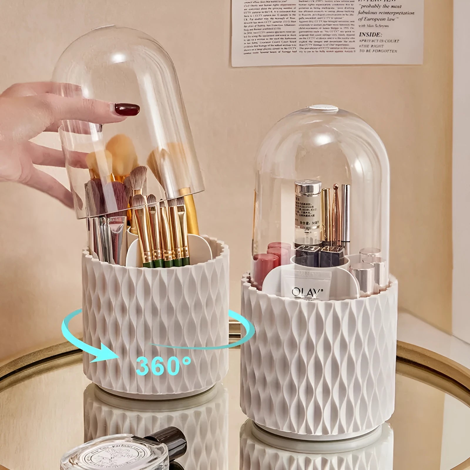 White acrylic rotating makeup brush holder with transparent body and a grey dust cover on a desk.