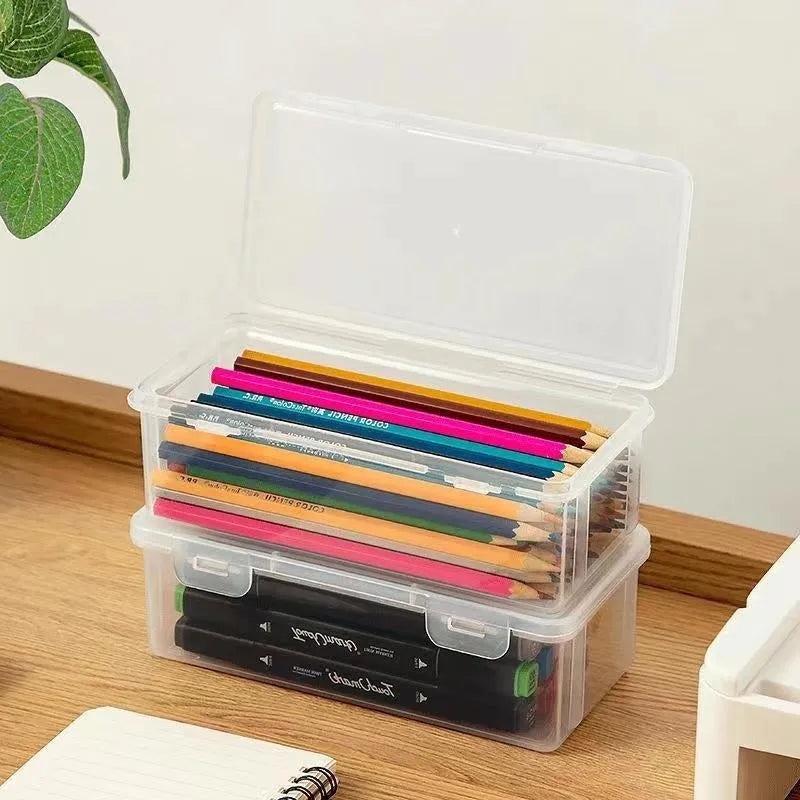 Transparent plastic storage box containing coloured pencils and drawing materials