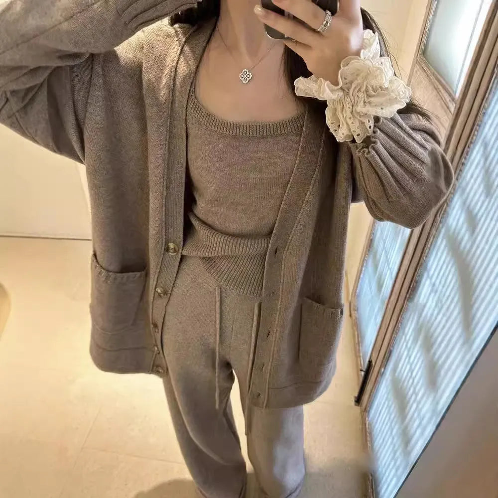Women's loose-fit wool-blend cardigan three-piece set with vest and suspender trousers in beige.