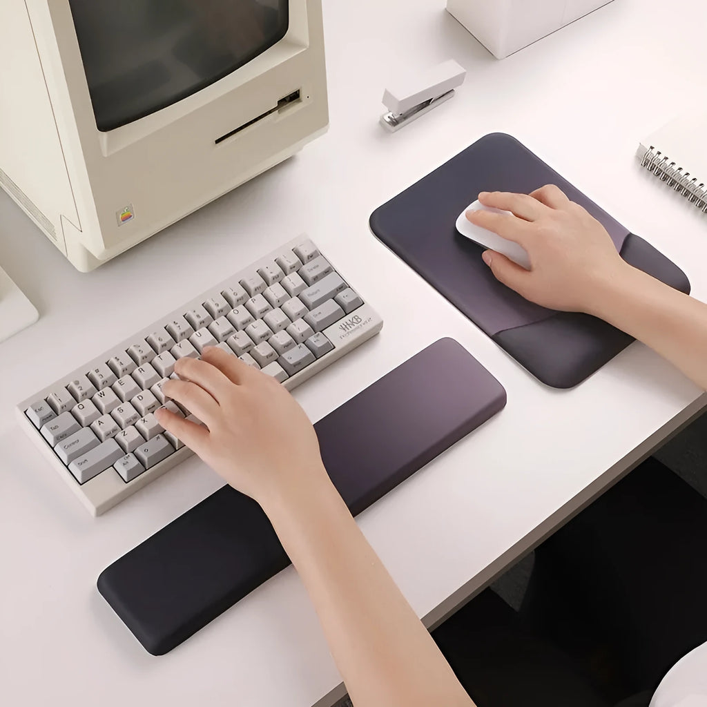 Square blue cloth silicone wrist rest mouse pad on a desk.