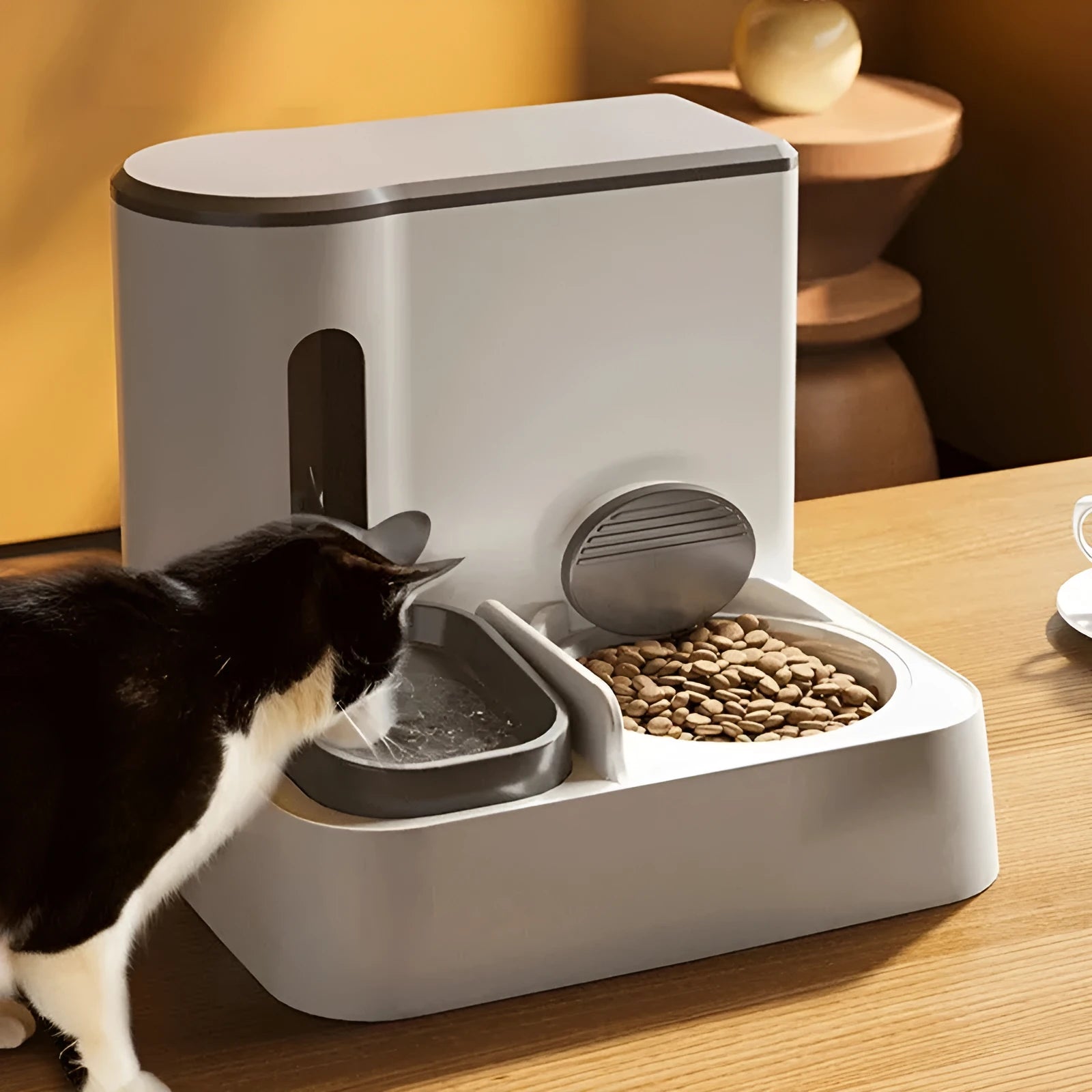Grey automatic cat feeder and water dispenser unit with two bowls.