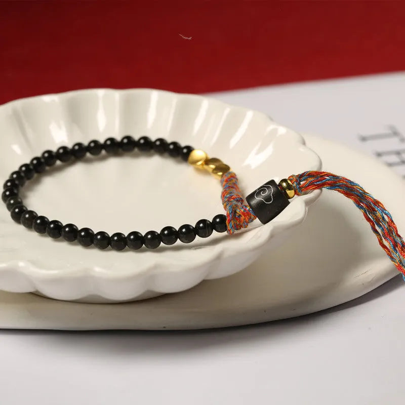 Hand-woven obsidian carrying strap bracelet showing textured detail and adjustable 15.5-16cm length